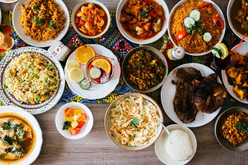 African feast with rice, stews, greens, chicken and shared plates